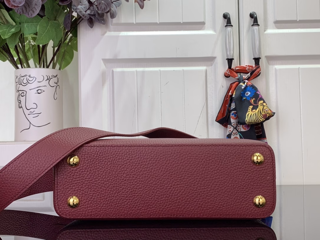 The Capucines bb bag features light blue Taurillon leather for a sophisticated feminine appeal, juxtaposed with precious Karung leather on the flap and top handle. Although soft to the touch, Karung leather is extremely durable, making it long-lasting. In addition to the iconic top handle, the Capucines also features a wide, removable shoulder strap.